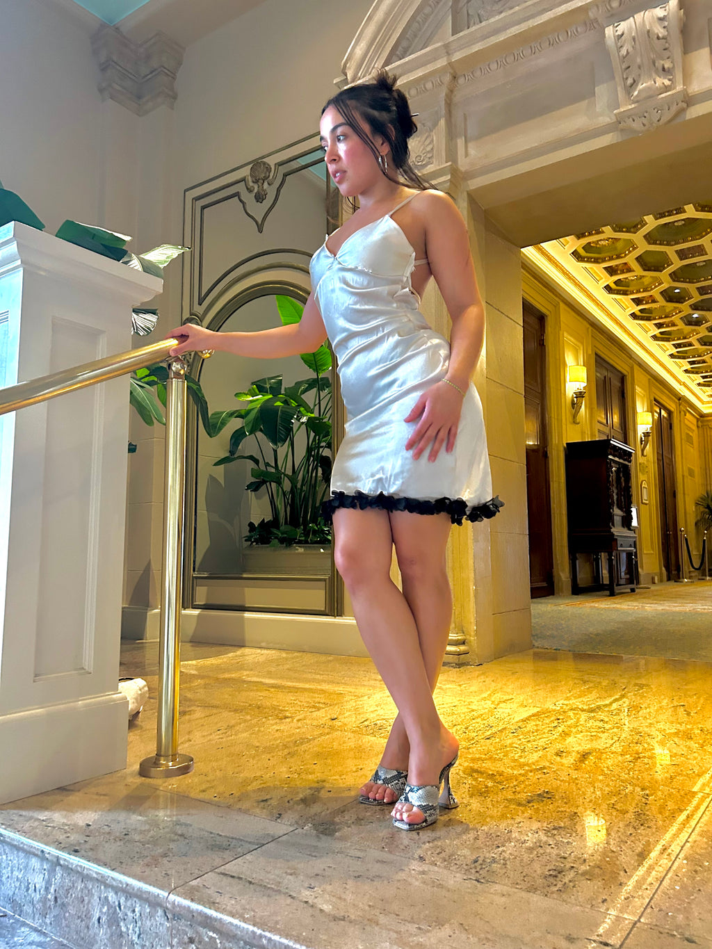 Woman in a white dress standing in an elegant interior setting