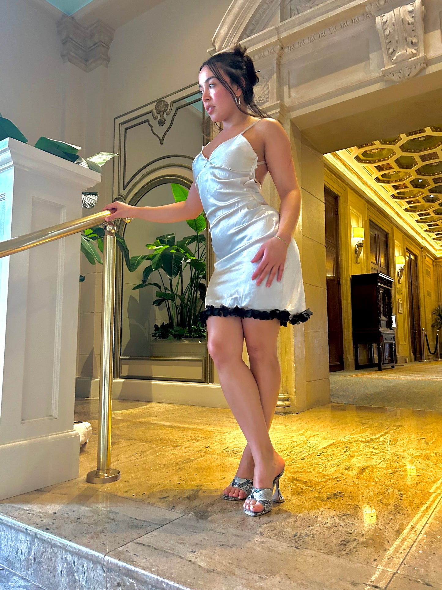 Woman in a white dress standing in an elegant interior setting