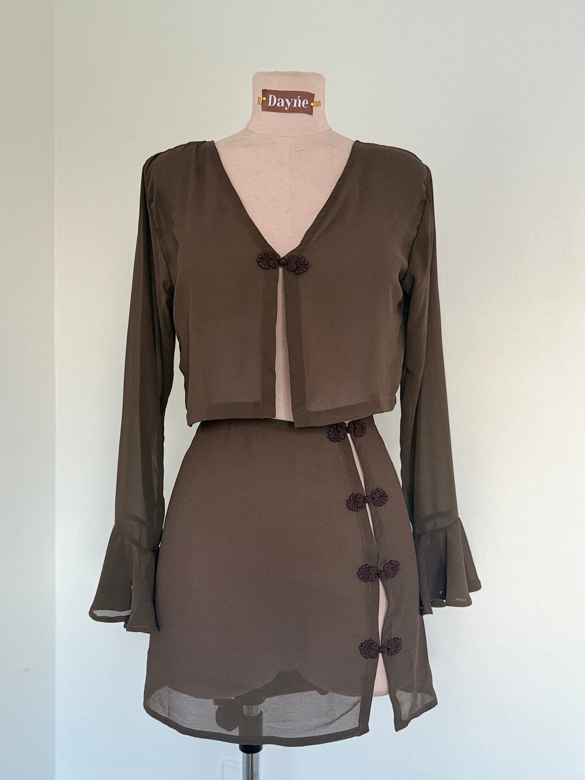 Brown dress on a mannequin with a plain background