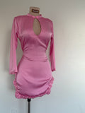 Pink dress with long sleeves on a mannequin against a plain background