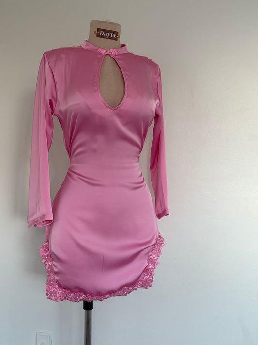 Pink dress with long sleeves on a mannequin against a plain background